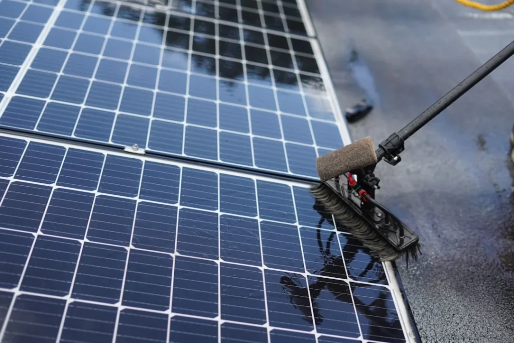 pode lavar placa solar com sol quente — Técnico realizando limpeza de placa solar com sol quente — cuidados e horário co