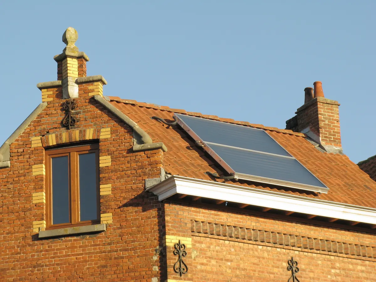 Dois coletores de aquecedor solar no telhado de uma casa de tijolo (foto ilustrativa)