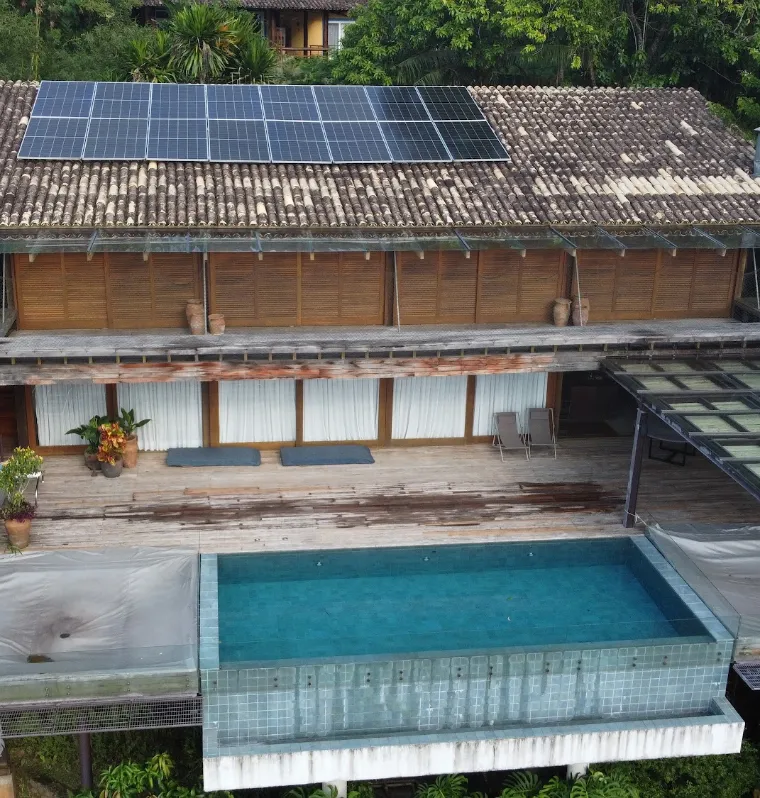 Residência de alto padrão em Ilhabela/SP com painéis de energia solar no telhado e piscina de borda infinita
