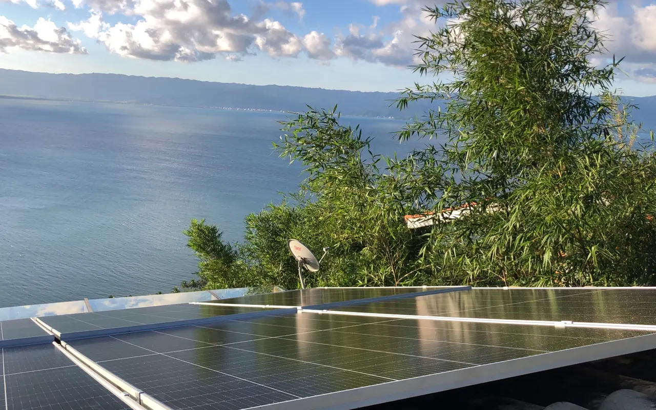 Placas solares instaladas pela RE Solar numa residência em Ilhabela/SP, com o mar ao fundo