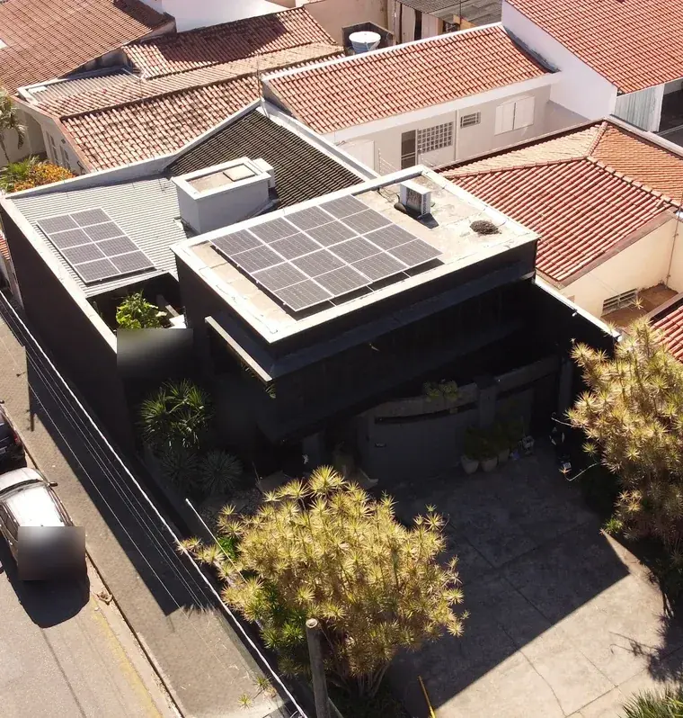 Vista aérea de escritório de arquitetura em Sorocaba/SP, prédio preto contemporâneo com 12 módulos fotovoltaicos em duas áreas da cobertura.