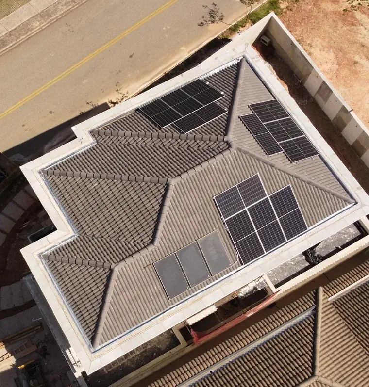 Vista aérea de residência em Sorocaba/SP com telhado de telhas e três conjuntos de módulos fotovoltaicos