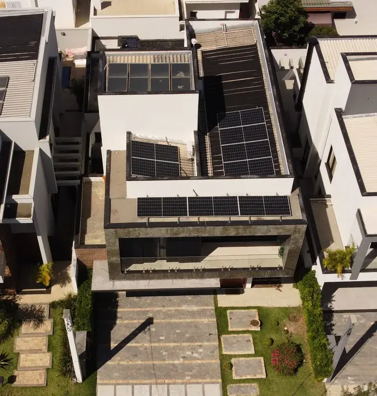 Vista aérea frontal de residência em condomínio de Sorocaba/SP com módulos fotovoltaicos na laje da fachada e nas coberturas